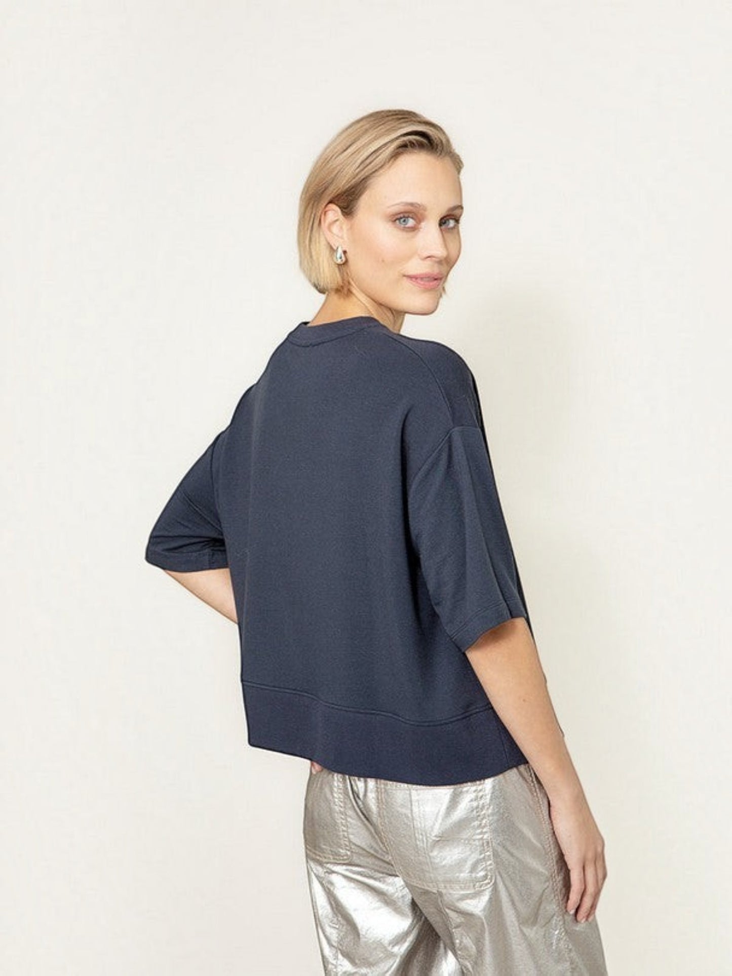 Model draagt een donkerblauw oversized T-shirt van webshop Isabelle Fashion met korte mouwen en een ronde hals.