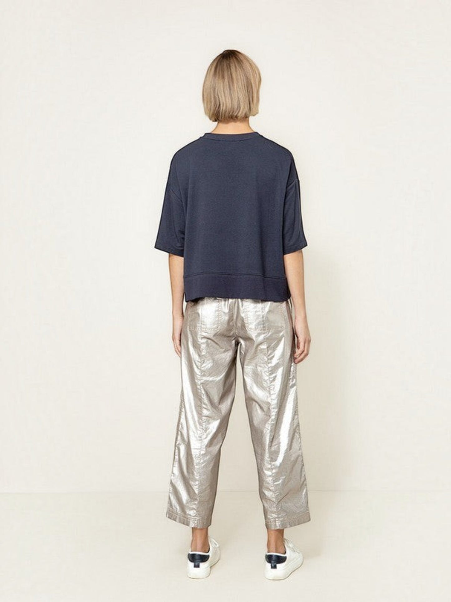 Achterkant van een donkerblauw oversized T-shirt van webshop Isabelle Fashion gecombineerd met een zilveren broek.