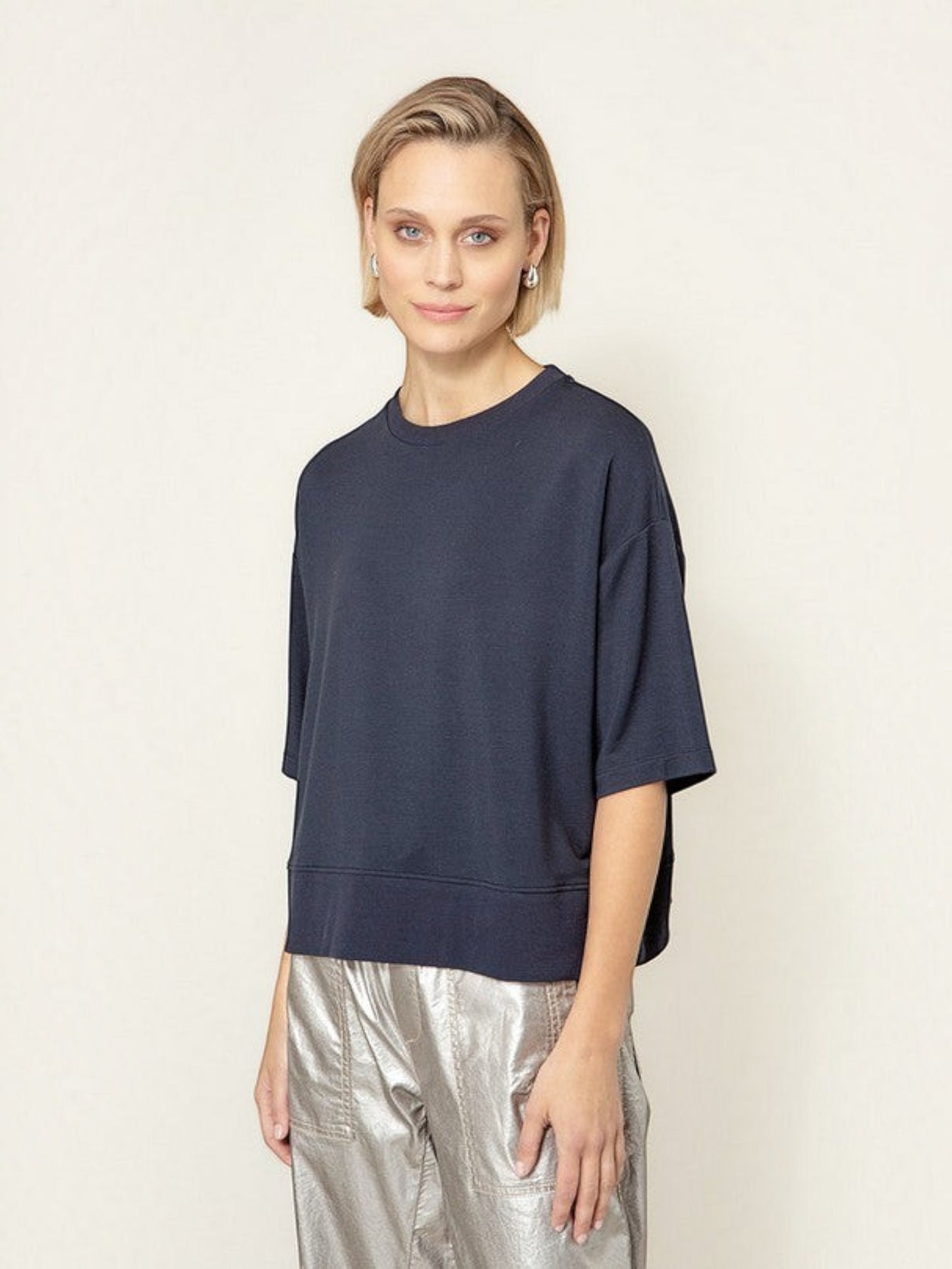Model draagt een donkerblauw oversized T-shirt van webshop Isabelle Fashion met korte mouwen en een ronde hals.