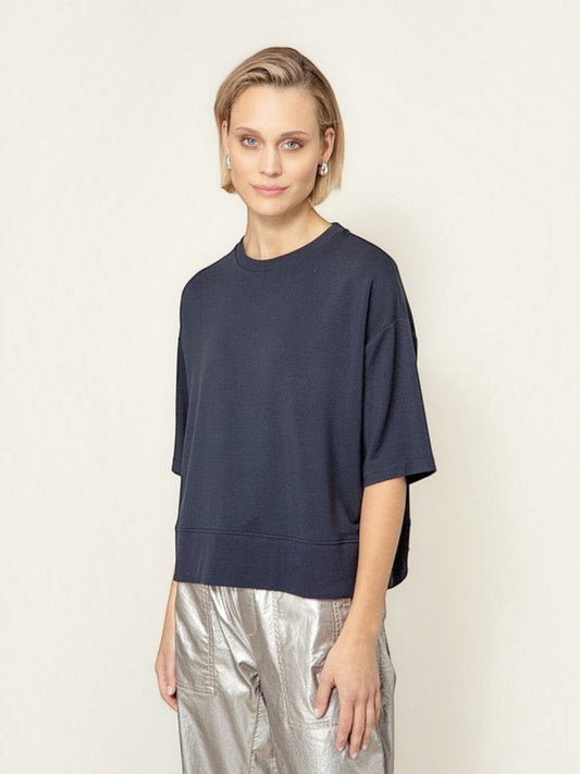 Model draagt een donkerblauw oversized T-shirt van webshop Isabelle Fashion met korte mouwen en een ronde hals.